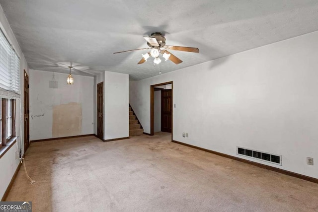 unfurnished room featuring a textured ceiling, light colored carpet, and ceiling fan