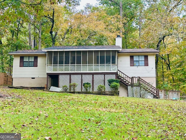 back of property with a sunroom and a yard