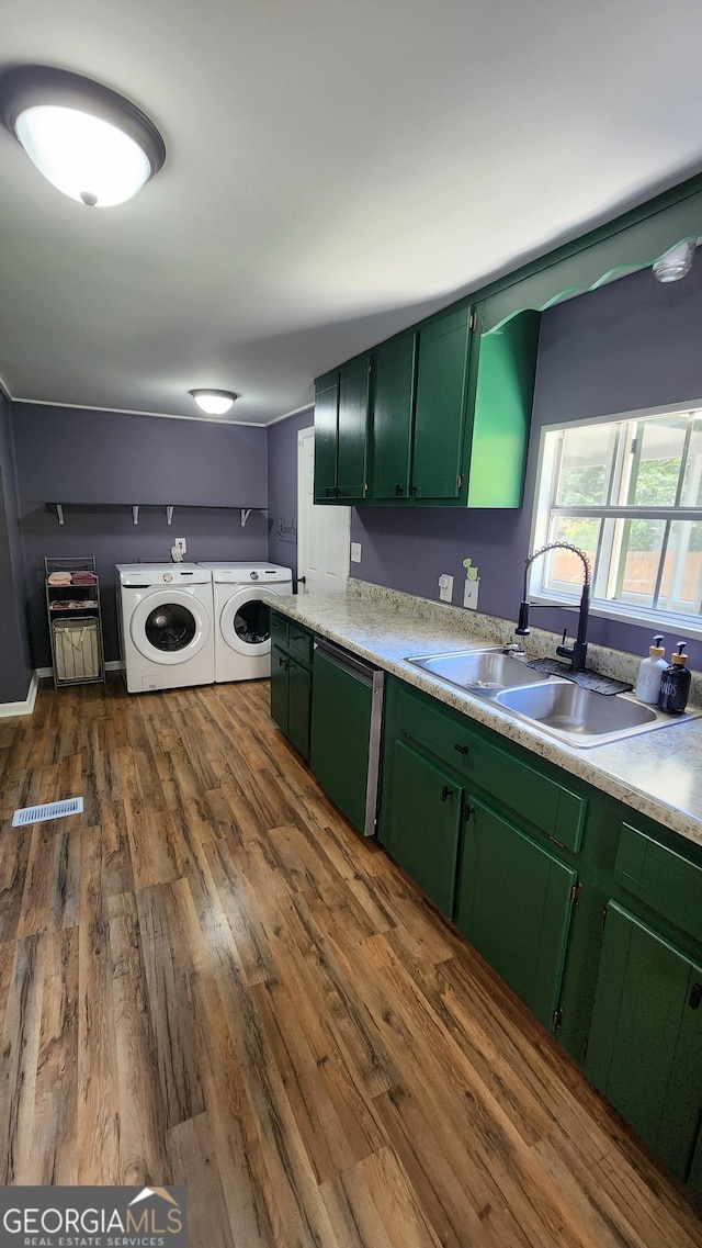 kitchen featuring washer and clothes dryer, dark hardwood / wood-style floors, sink, and green cabinetry