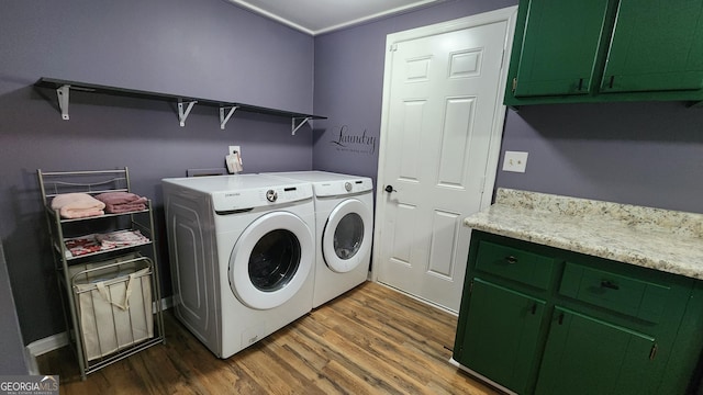 washroom featuring washer and clothes dryer, dark hardwood / wood-style floors, and cabinets