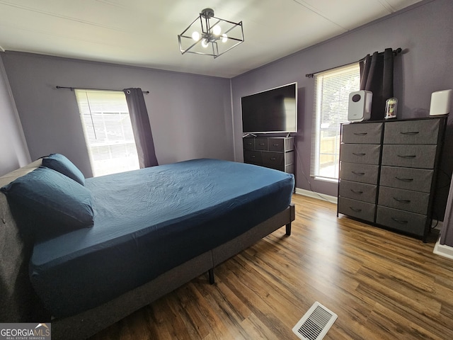 bedroom featuring hardwood / wood-style floors and a chandelier