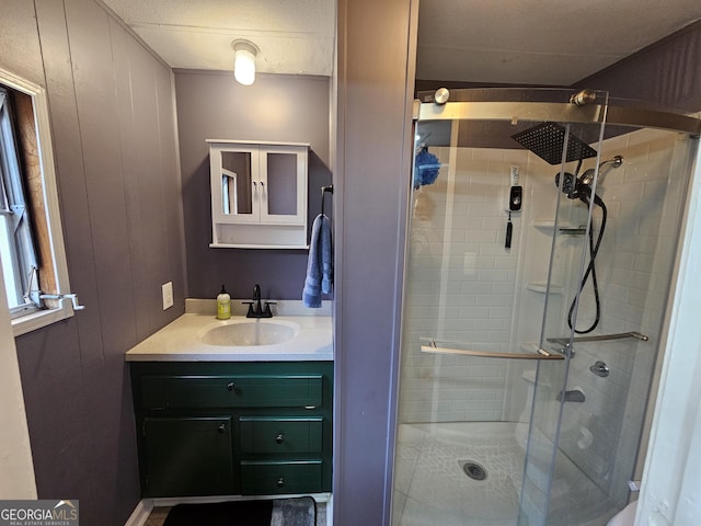 bathroom with wood walls, a shower with door, and vanity