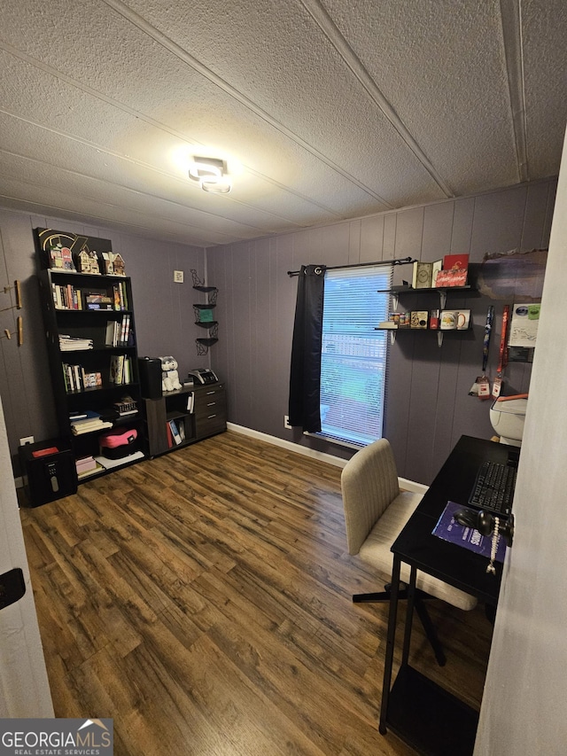 office with hardwood / wood-style floors, a textured ceiling, and wooden walls