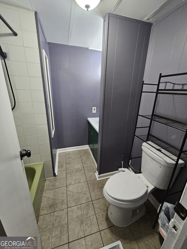 bathroom featuring toilet, a textured ceiling, vanity, and tile patterned floors