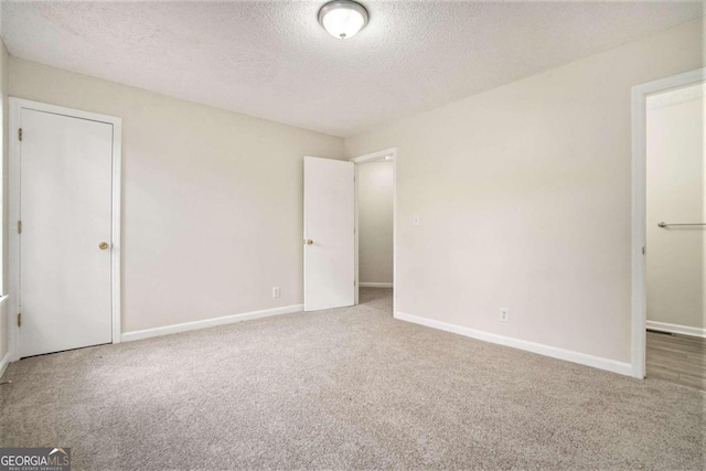 unfurnished bedroom featuring a textured ceiling and carpet floors