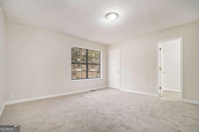 unfurnished room with a textured ceiling and carpet floors