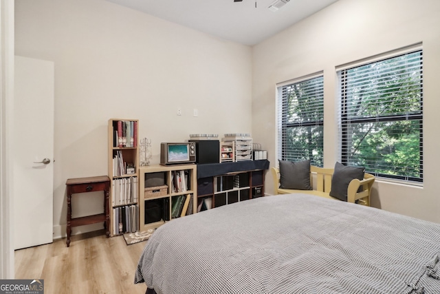 bedroom with light hardwood / wood-style floors and multiple windows