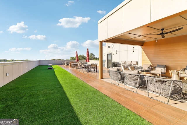 view of yard featuring outdoor lounge area, ceiling fan, and a patio area