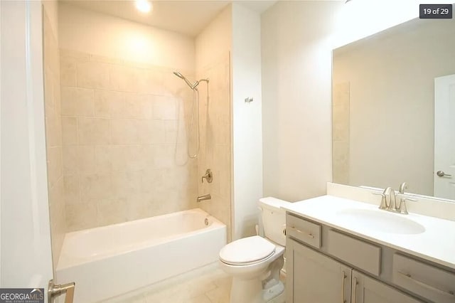 full bathroom with toilet, vanity, and tiled shower / bath