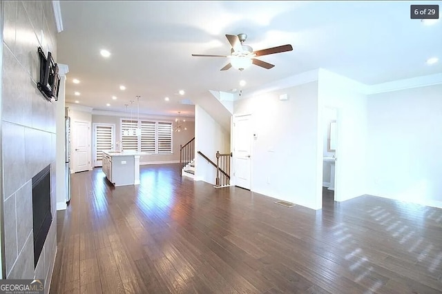 unfurnished living room with a fireplace, crown molding, dark hardwood / wood-style flooring, and ceiling fan