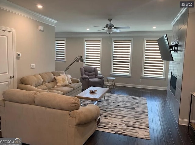 living room featuring a tiled fireplace, ceiling fan, dark hardwood / wood-style floors, and ornamental molding