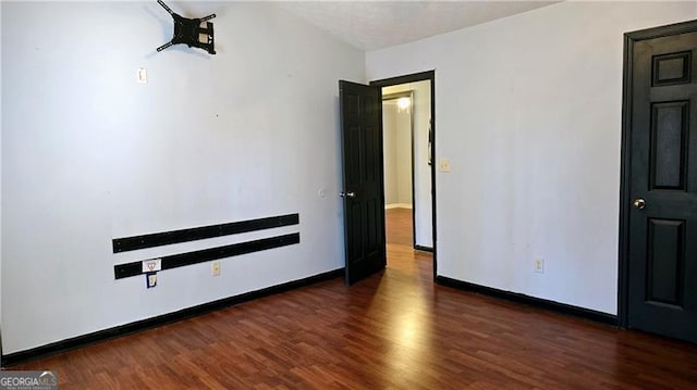 empty room featuring dark hardwood / wood-style flooring