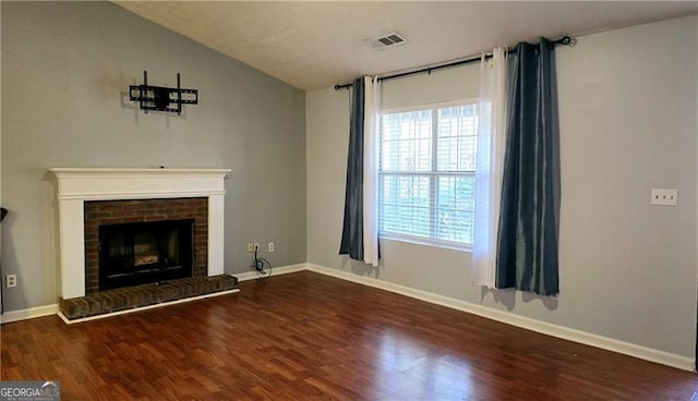 unfurnished living room with dark hardwood / wood-style floors, vaulted ceiling, and a brick fireplace