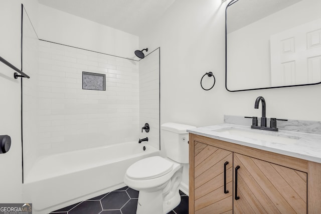 full bathroom featuring tile patterned floors, vanity, a textured ceiling, tiled shower / bath combo, and toilet