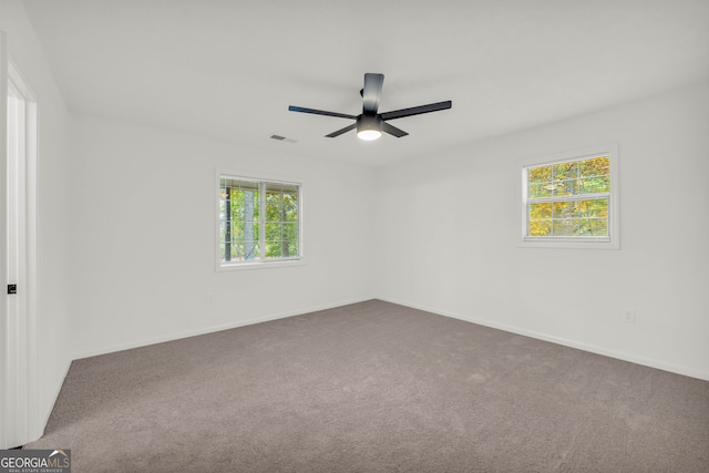 carpeted empty room featuring ceiling fan and a healthy amount of sunlight