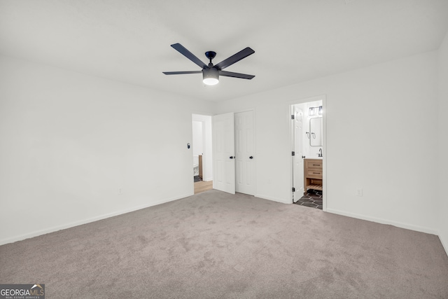 unfurnished bedroom featuring connected bathroom, a closet, ceiling fan, and carpet floors