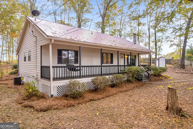 view of front of property with an outbuilding, a porch, central AC, and a garage