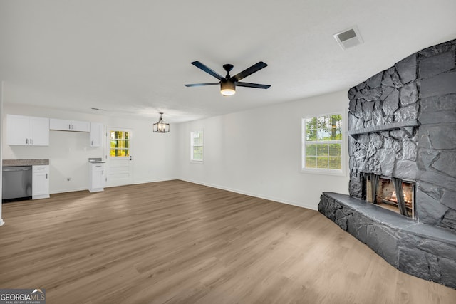 unfurnished living room with a fireplace, ceiling fan, and light hardwood / wood-style flooring