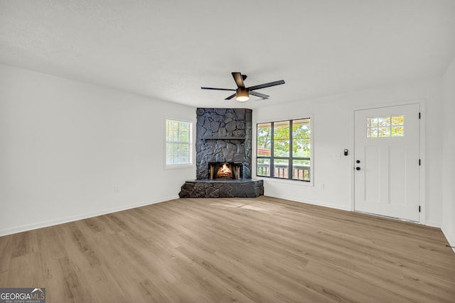 unfurnished living room with a fireplace, light hardwood / wood-style flooring, and a healthy amount of sunlight