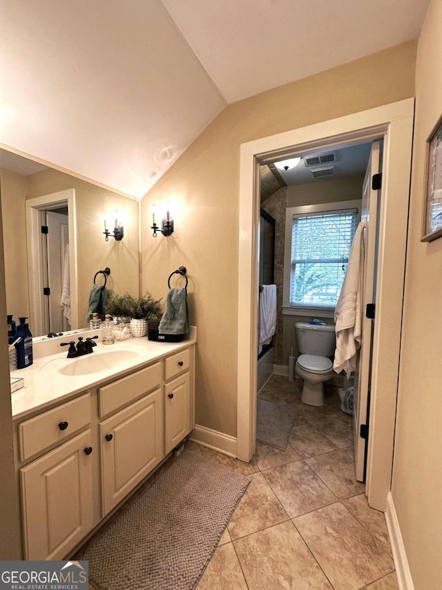 bathroom featuring vanity, tile patterned flooring, toilet, and vaulted ceiling