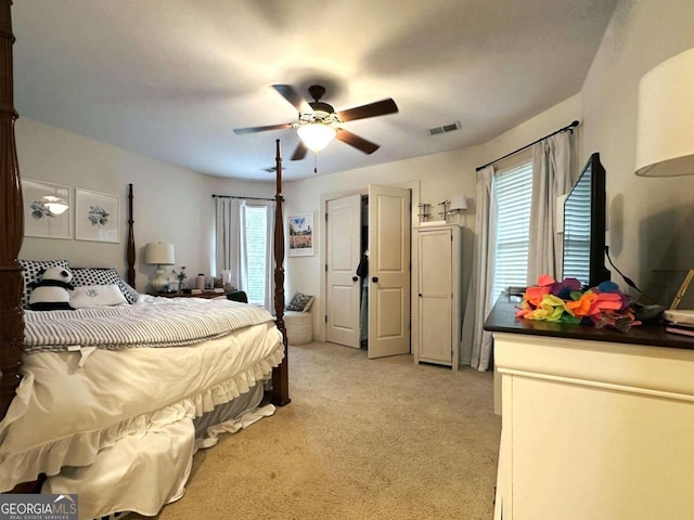 bedroom featuring light colored carpet, multiple windows, and ceiling fan