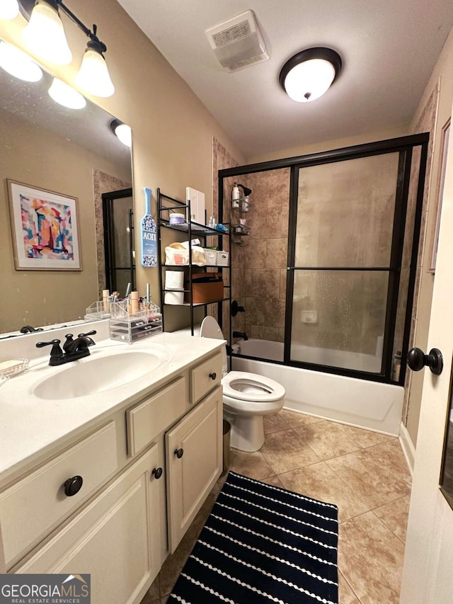 full bathroom with enclosed tub / shower combo, tile patterned flooring, vanity, and toilet