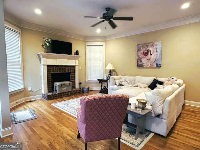 living room with ornamental molding, wood-type flooring, and ceiling fan