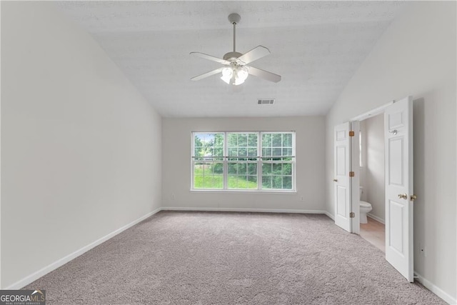 unfurnished bedroom with lofted ceiling, carpet flooring, baseboards, and visible vents