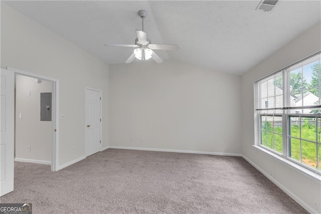 unfurnished room featuring carpet, visible vents, baseboards, electric panel, and vaulted ceiling