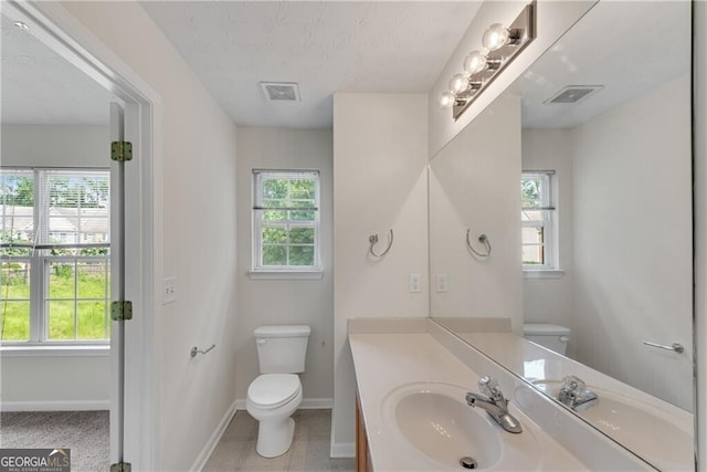 bathroom with visible vents, plenty of natural light, and toilet