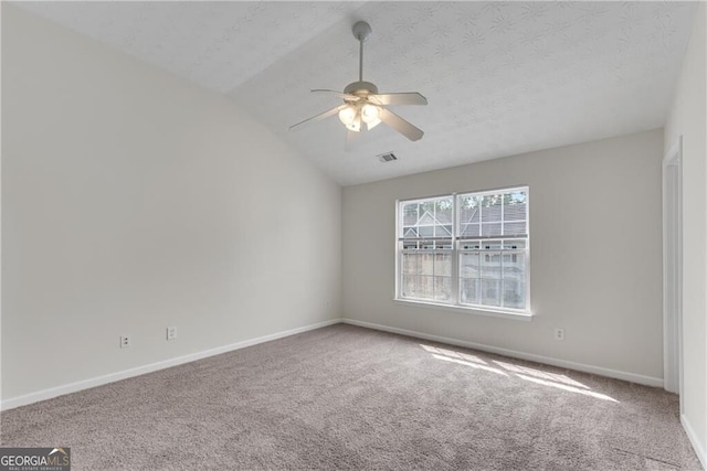 spare room featuring visible vents, carpet floors, baseboards, and vaulted ceiling