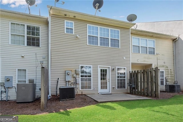 rear view of house featuring cooling unit, a patio, and a yard