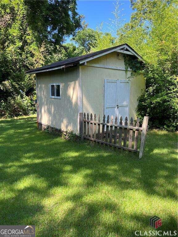 view of property exterior with a shed and a lawn