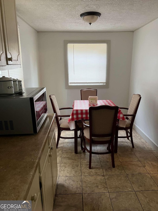 dining room featuring tile patterned flooring and a textured ceiling