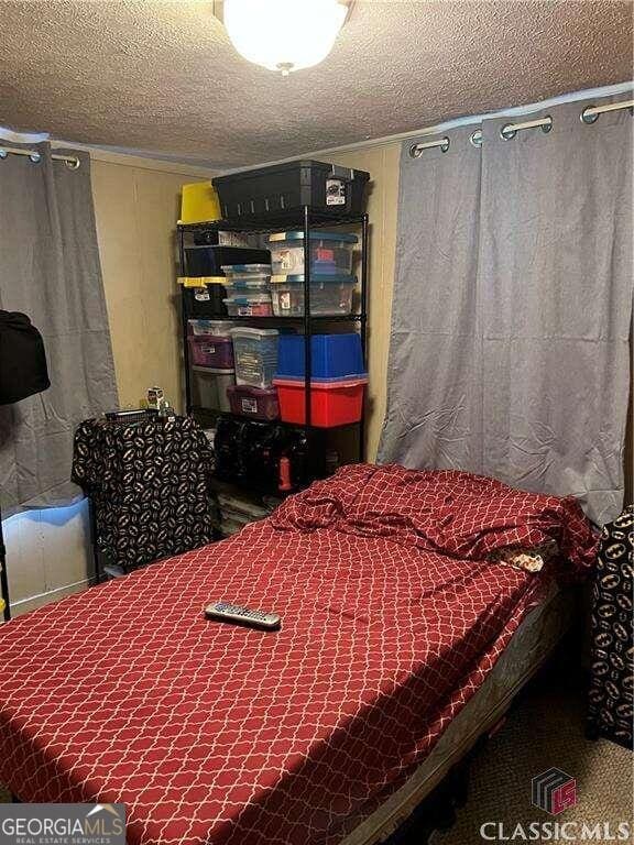 bedroom featuring a textured ceiling and carpet flooring