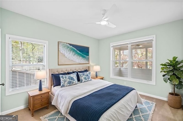 bedroom with multiple windows, light carpet, and ceiling fan