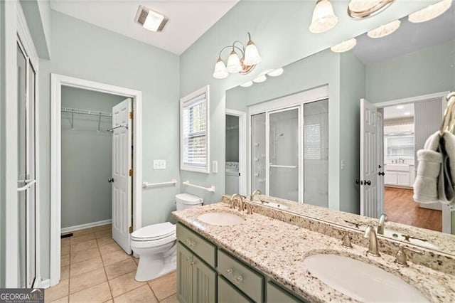 bathroom with toilet, vanity, tile patterned flooring, and a healthy amount of sunlight