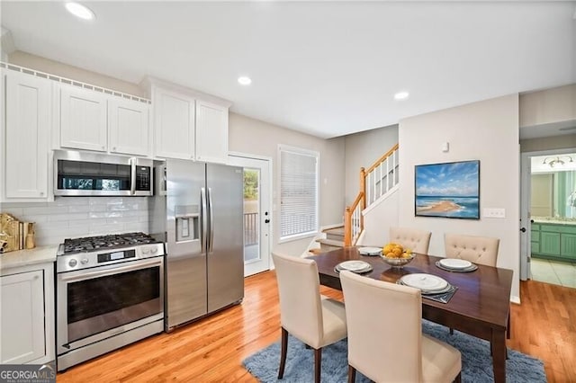 kitchen featuring white cabinets, light hardwood / wood-style flooring, and appliances with stainless steel finishes