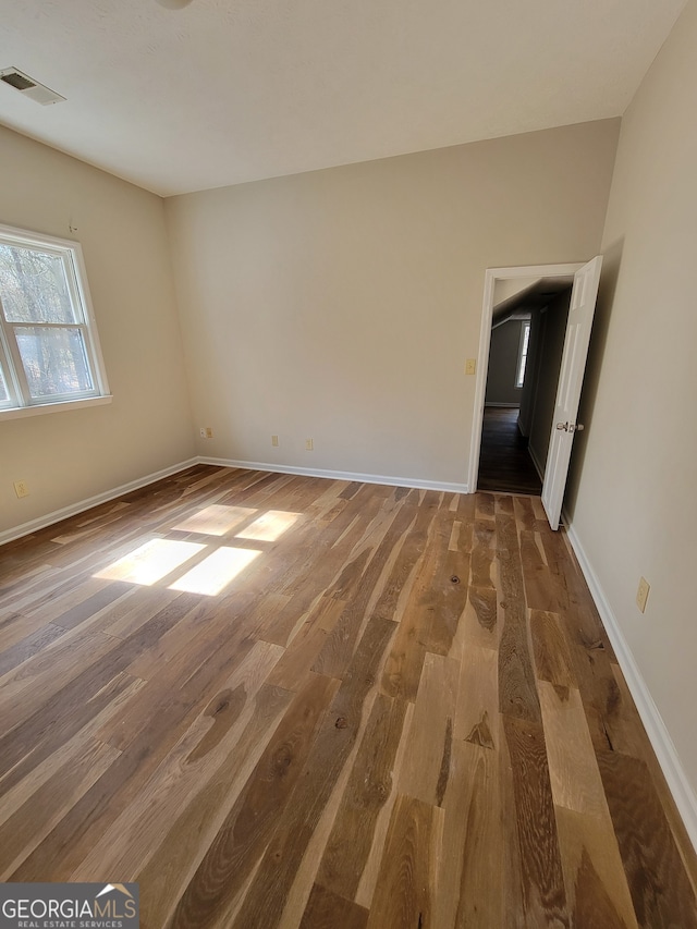 unfurnished room with hardwood / wood-style floors