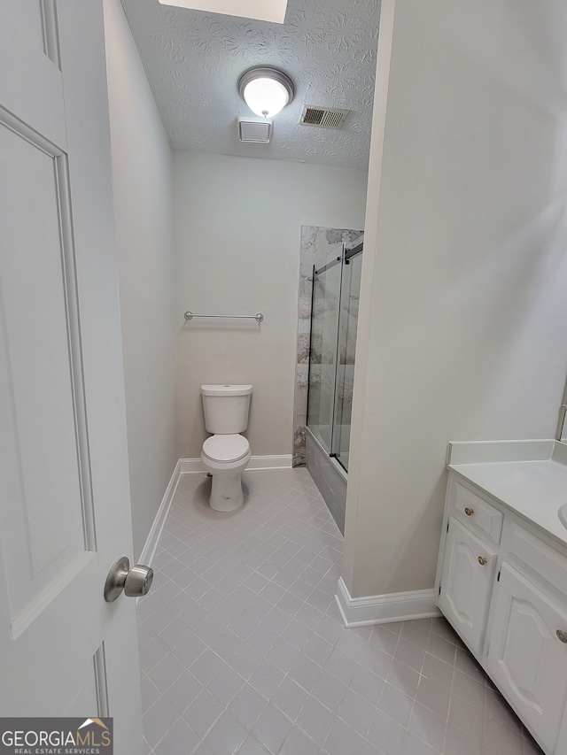 bathroom featuring walk in shower, a textured ceiling, vanity, tile patterned floors, and toilet