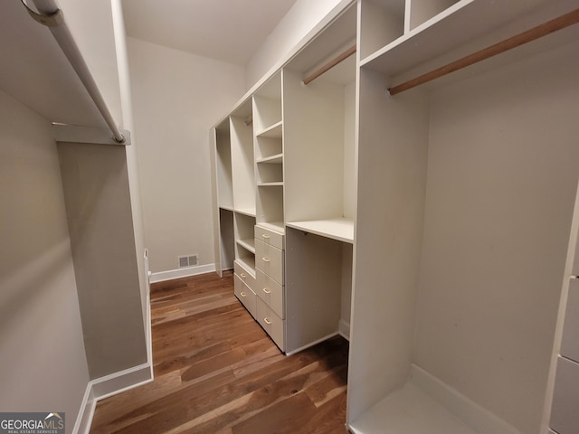 walk in closet with dark hardwood / wood-style floors