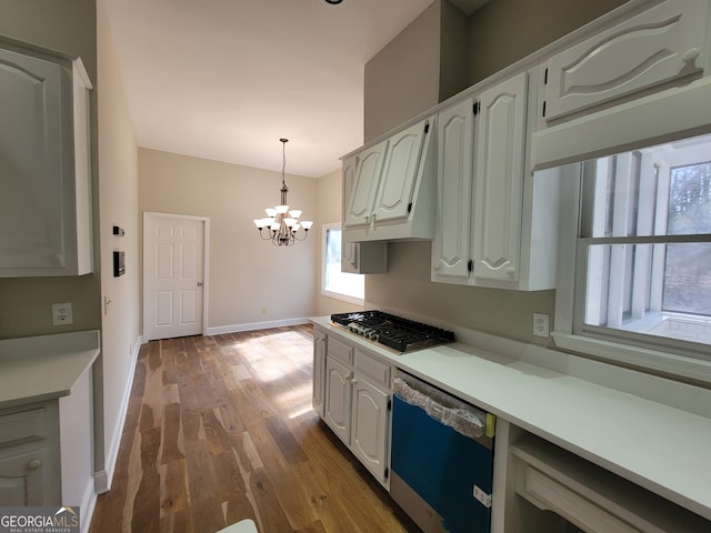 kitchen featuring white cabinetry, light wood-type flooring, stainless steel appliances, and a notable chandelier