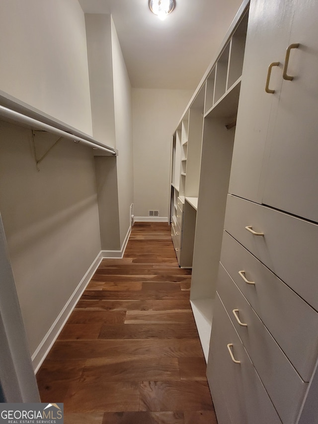 spacious closet featuring dark hardwood / wood-style flooring