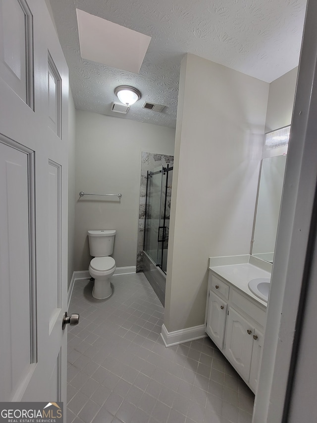 bathroom featuring toilet, tile patterned flooring, a textured ceiling, vanity, and walk in shower