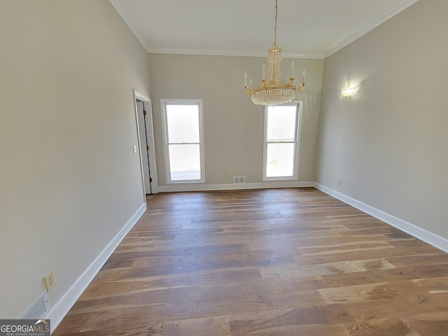 unfurnished dining area featuring an inviting chandelier, hardwood / wood-style flooring, and crown molding