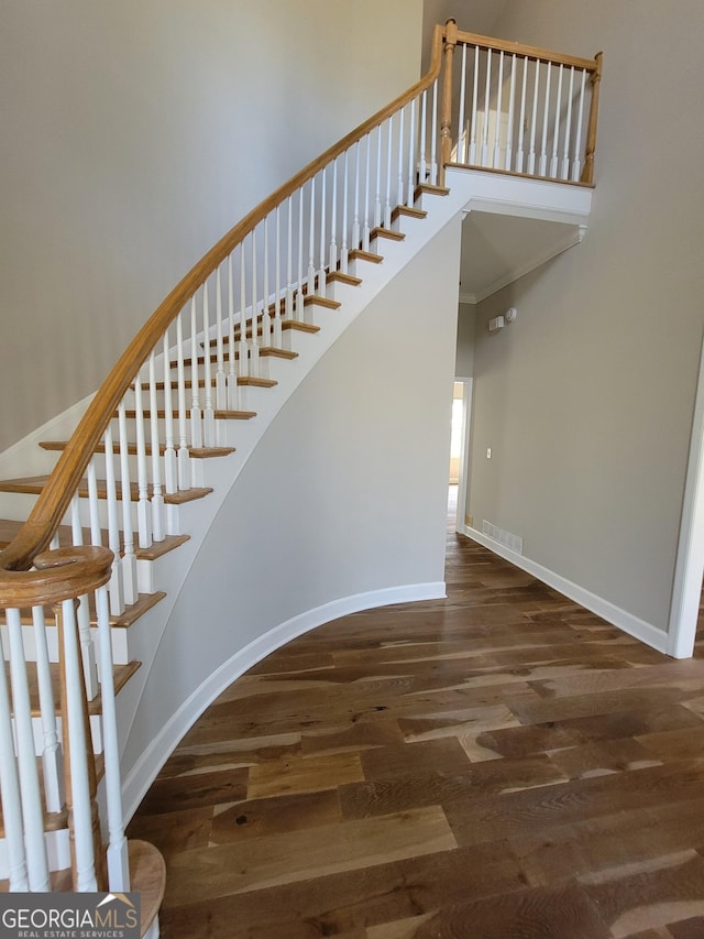 275 Allie Dr, Mcdonough, GA 30252 - stairs featuring wood finished floors, baseboards, arched walkways, and a towering ceiling