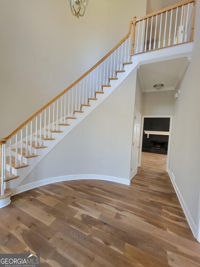 275 Allie Dr, Mcdonough, GA 30252 - staircase featuring wood finished floors, crown molding, baseboards, and a fireplace
