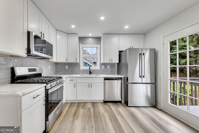 kitchen featuring light hardwood / wood-style floors, sink, white cabinets, and stainless steel appliances