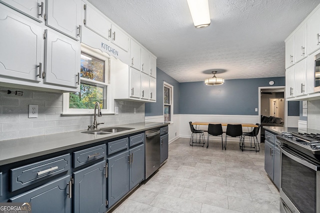 kitchen featuring white cabinets, decorative backsplash, sink, and appliances with stainless steel finishes