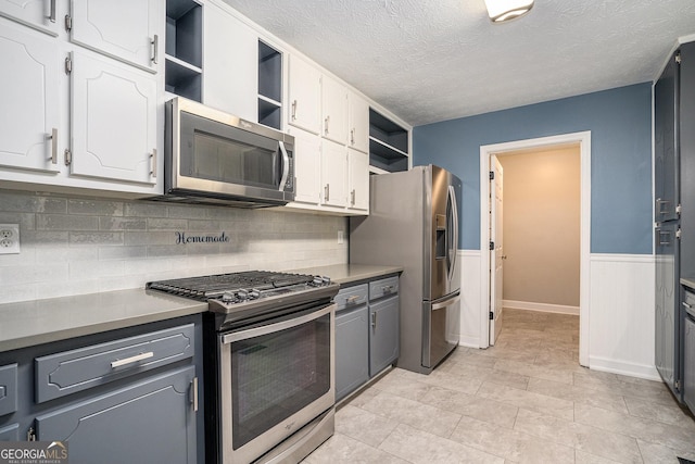 kitchen featuring appliances with stainless steel finishes, backsplash, white cabinetry, and gray cabinetry